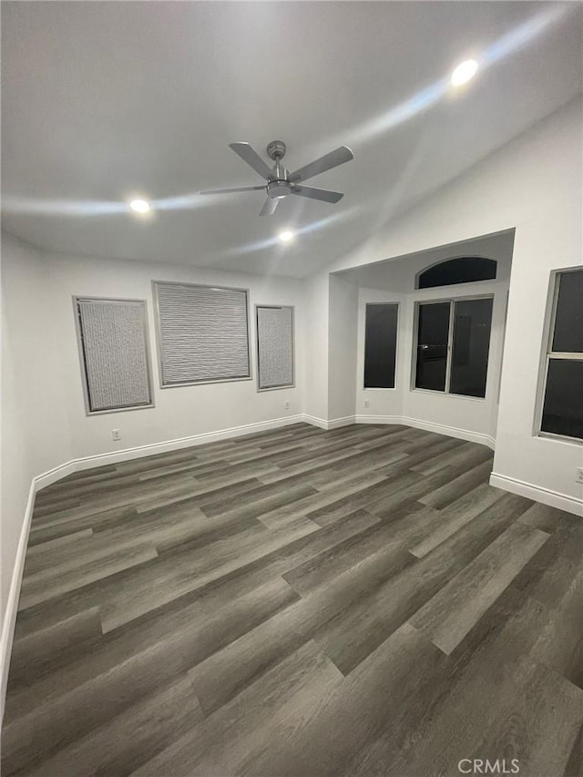 unfurnished room featuring dark hardwood / wood-style floors, vaulted ceiling, and ceiling fan