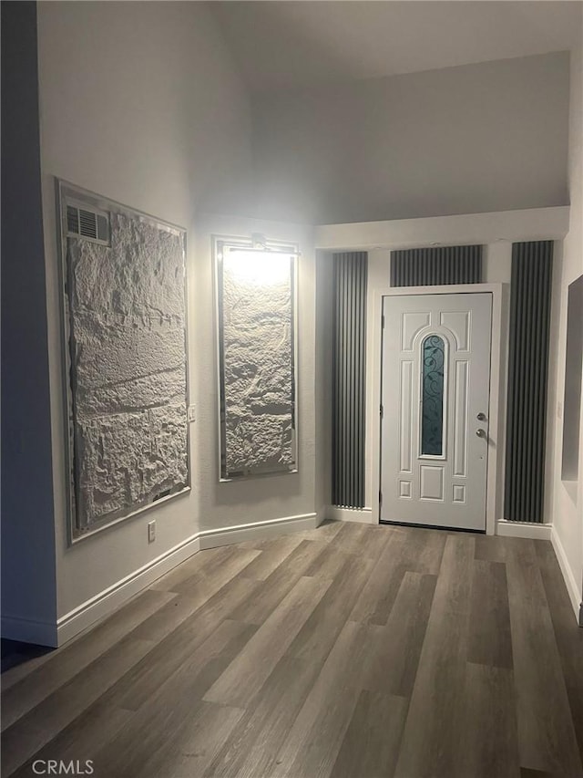 entrance foyer with dark hardwood / wood-style flooring and high vaulted ceiling