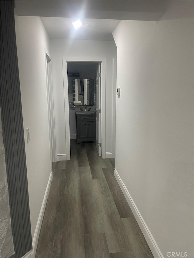 corridor featuring sink and dark wood-type flooring