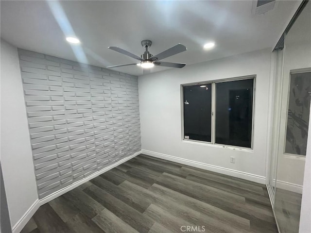 spare room featuring ceiling fan and dark wood-type flooring