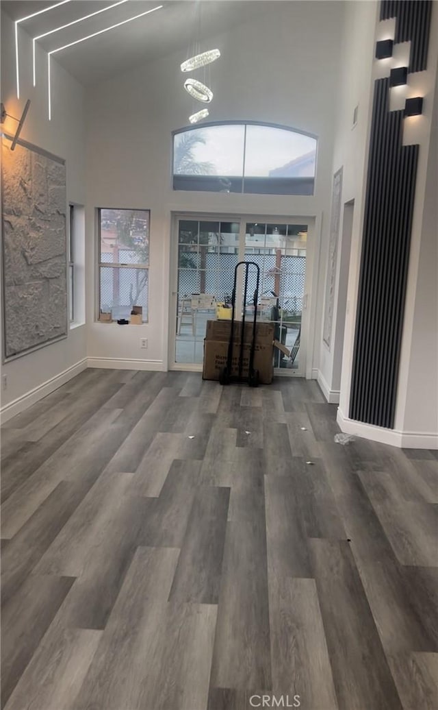 interior space featuring a notable chandelier, dark hardwood / wood-style flooring, and a high ceiling