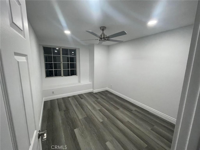 empty room with ceiling fan and dark hardwood / wood-style flooring