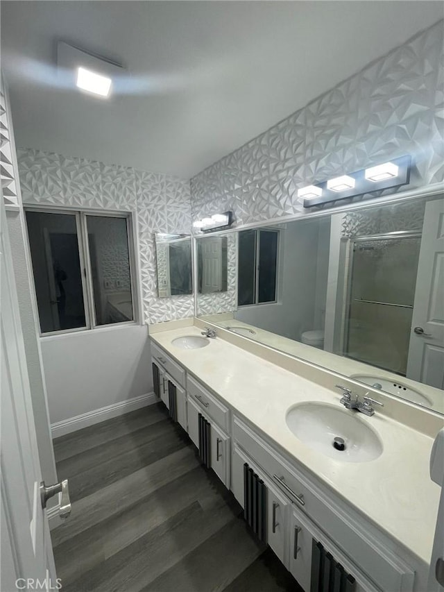 bathroom featuring wood-type flooring, vanity, toilet, and walk in shower