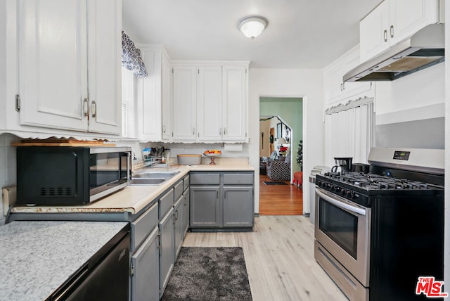 kitchen with gray cabinets, light hardwood / wood-style floors, white cabinets, and stainless steel appliances