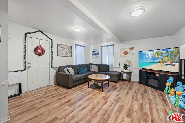 living room featuring beamed ceiling and light hardwood / wood-style floors