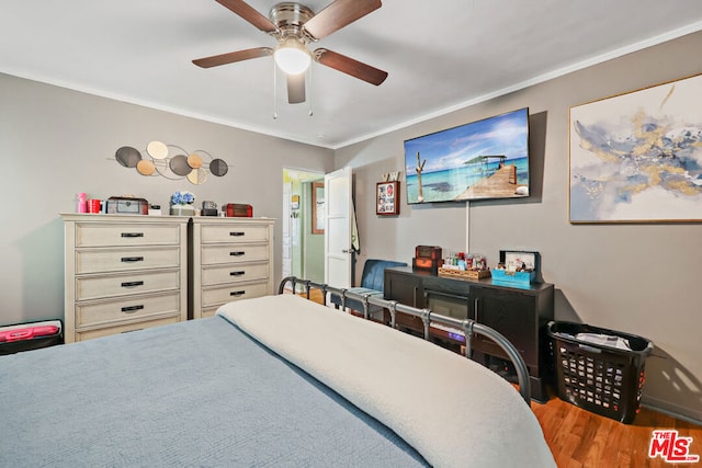 bedroom with wood-type flooring, ceiling fan, and ornamental molding