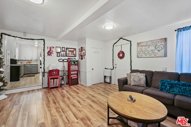 living room featuring beam ceiling and light hardwood / wood-style flooring