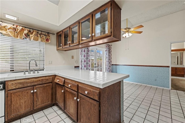 kitchen featuring tile countertops, ceiling fan, kitchen peninsula, and light tile patterned floors