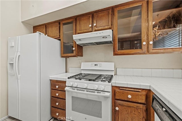 kitchen featuring tile counters and white appliances