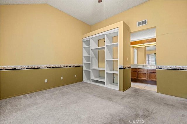 unfurnished bedroom featuring light carpet and vaulted ceiling