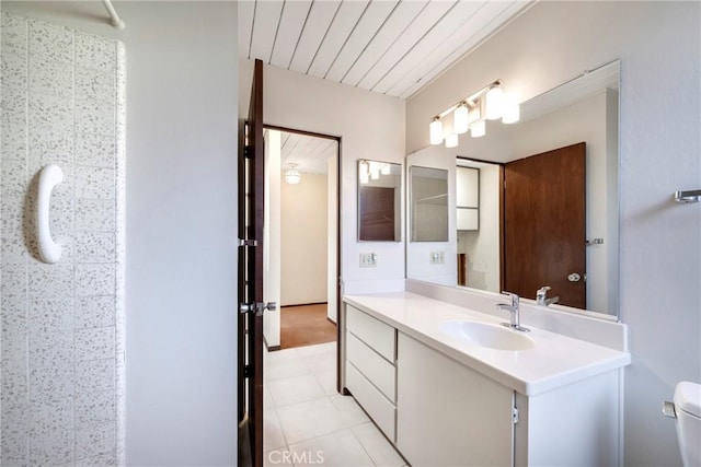 bathroom featuring toilet, vanity, and tile patterned flooring