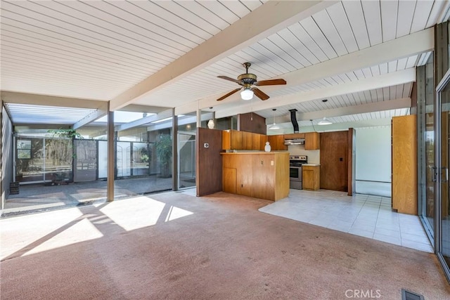 unfurnished living room featuring light carpet, ceiling fan, beamed ceiling, and floor to ceiling windows