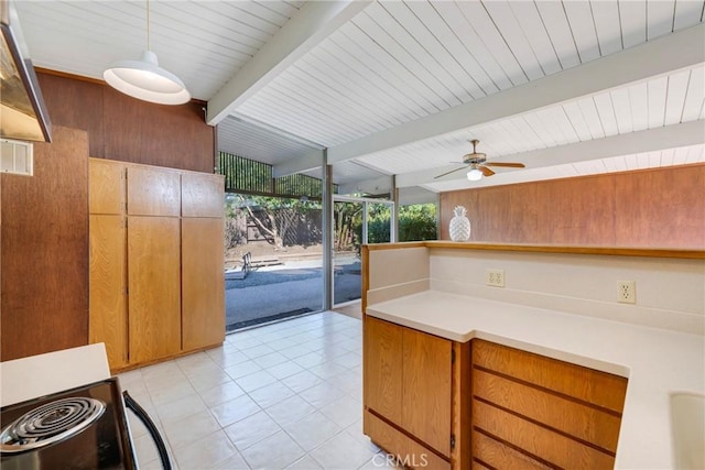 kitchen featuring light tile patterned floors, floor to ceiling windows, ceiling fan, hanging light fixtures, and lofted ceiling with beams