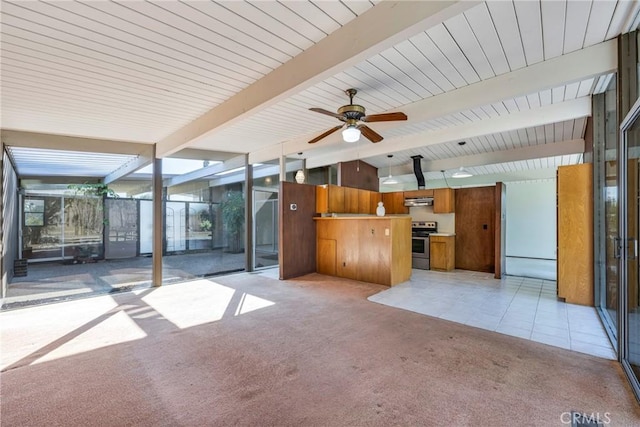 unfurnished living room with ceiling fan, light colored carpet, a wall of windows, and beamed ceiling