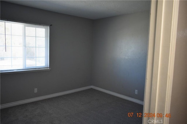 carpeted spare room with a textured ceiling