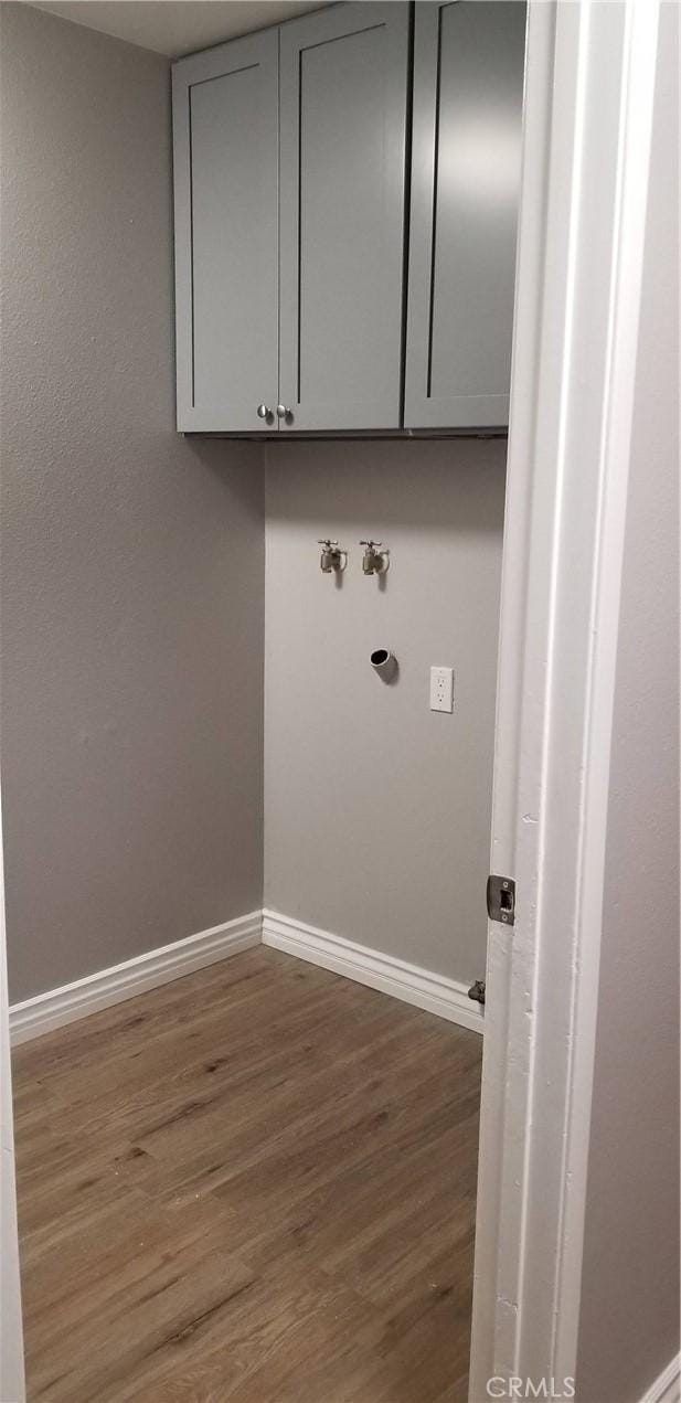 laundry area with cabinets, dark hardwood / wood-style flooring, and washer hookup