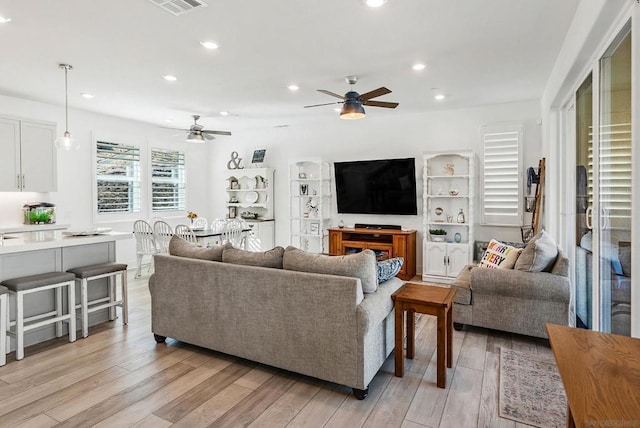 living room featuring ceiling fan and light wood-type flooring