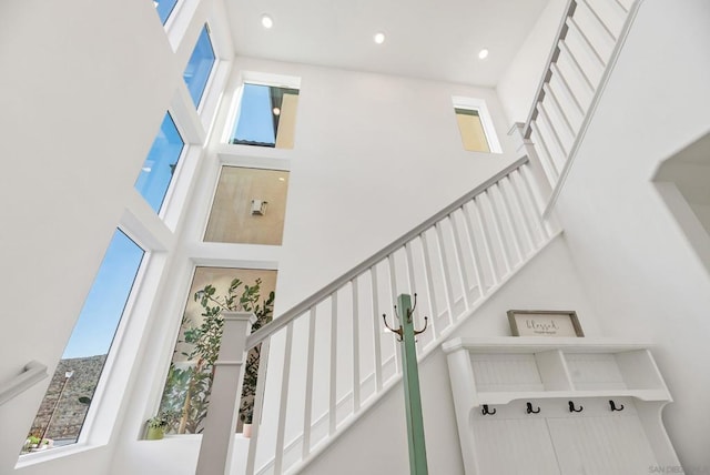 stairway with a high ceiling and plenty of natural light