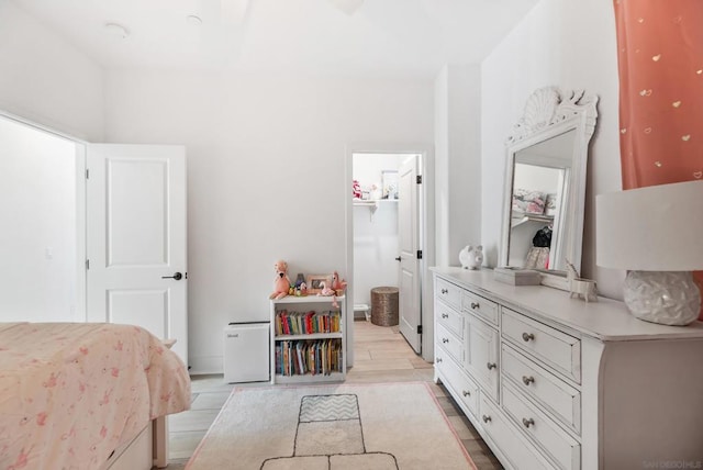 bedroom featuring a spacious closet, a closet, and light hardwood / wood-style floors