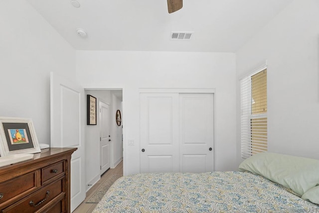 bedroom featuring ceiling fan, light wood-type flooring, and a closet