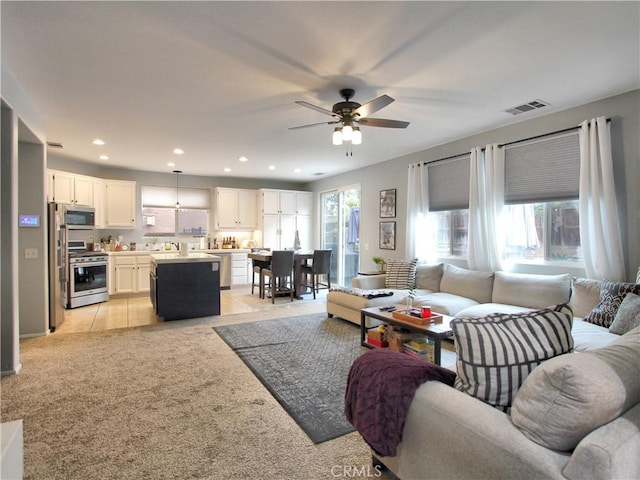 tiled living room featuring ceiling fan and plenty of natural light