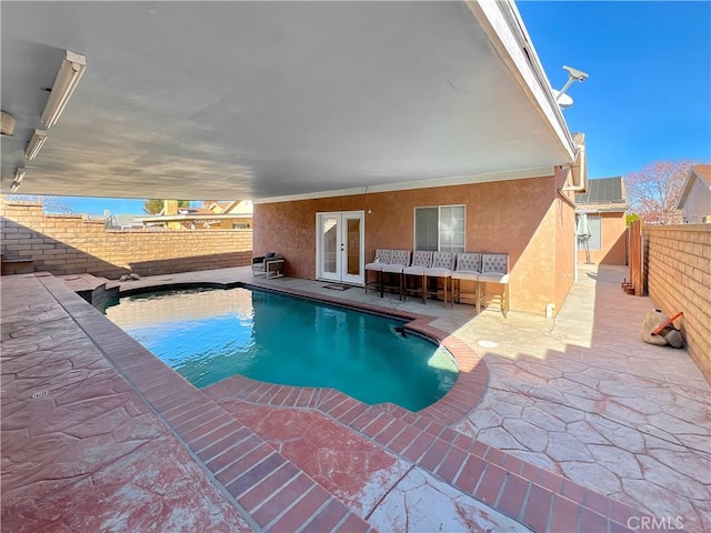 view of swimming pool with french doors and a patio