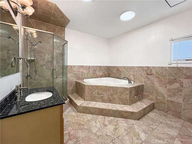 bathroom featuring plus walk in shower, vanity, and tile walls