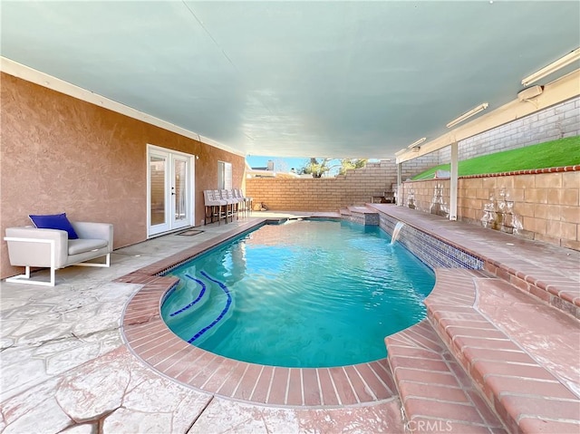 view of swimming pool with french doors, pool water feature, and a patio