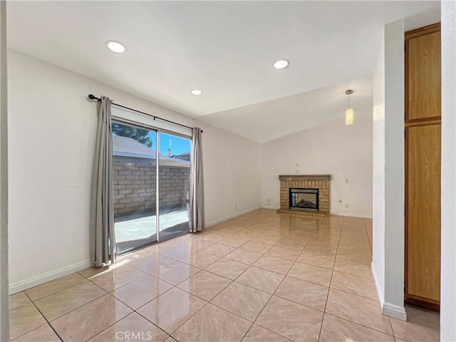 unfurnished living room featuring light tile patterned floors, a brick fireplace, and lofted ceiling