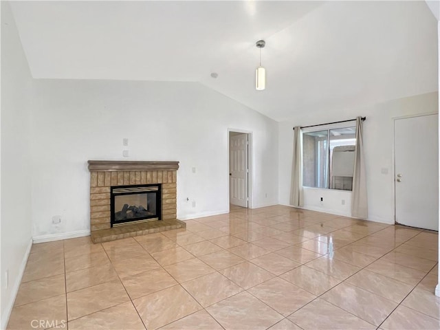 unfurnished living room with a fireplace, light tile patterned floors, and vaulted ceiling