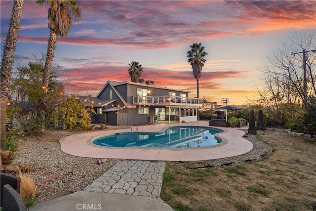 pool at dusk with a patio