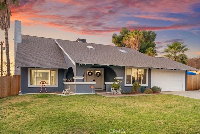 ranch-style house with a garage, fence, concrete driveway, and a front yard