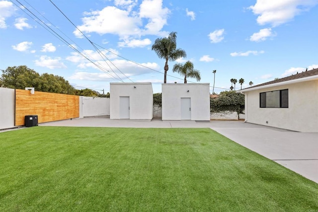 back of house with a yard and a patio