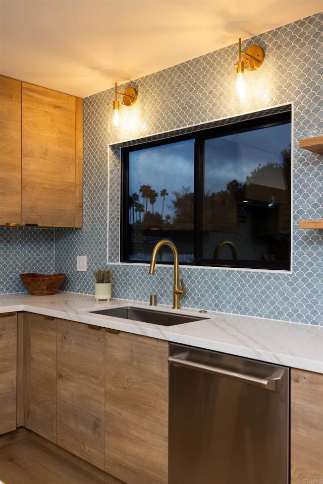 kitchen with stainless steel dishwasher, backsplash, sink, and hardwood / wood-style floors