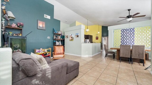 living room with lofted ceiling, light tile patterned floors, and ceiling fan