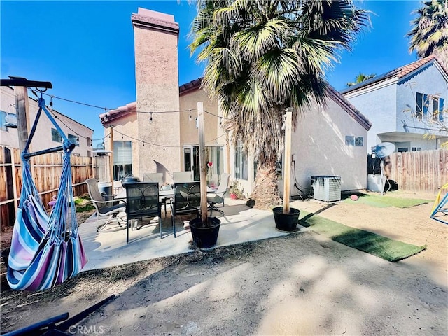 rear view of property featuring cooling unit and a patio