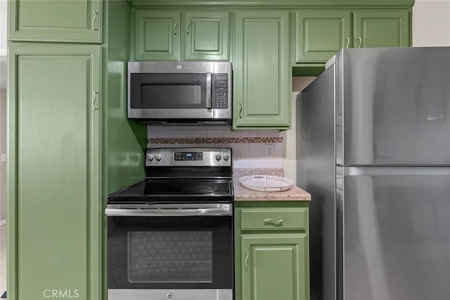 kitchen with decorative backsplash, green cabinetry, and appliances with stainless steel finishes