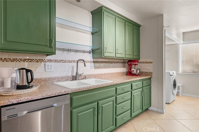 kitchen featuring sink, stainless steel dishwasher, independent washer and dryer, tasteful backsplash, and light tile patterned flooring