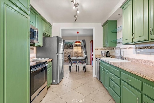 kitchen with green cabinets, light tile patterned floors, sink, and appliances with stainless steel finishes