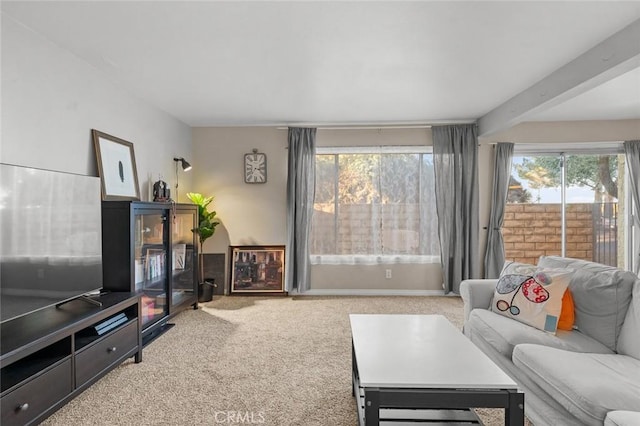 carpeted living room featuring beamed ceiling