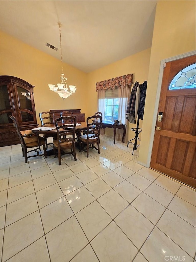 dining space featuring light tile patterned floors and a chandelier