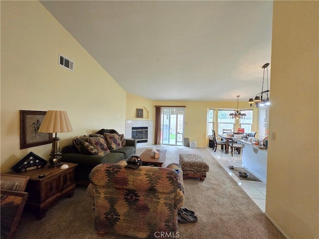 tiled living room featuring a fireplace, vaulted ceiling, and an inviting chandelier