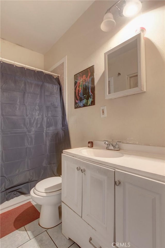 bathroom featuring toilet, vanity, tile patterned floors, and curtained shower