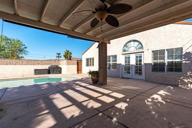 view of patio with a fenced in pool, area for grilling, and ceiling fan