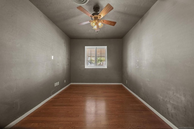 empty room with dark hardwood / wood-style floors and ceiling fan