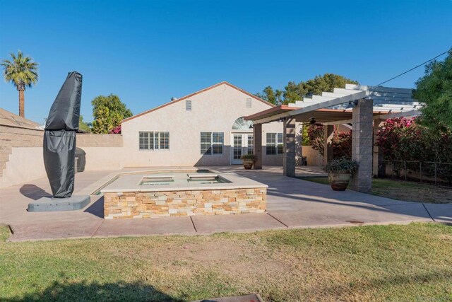 back of property featuring a pergola, ceiling fan, a patio area, and a lawn