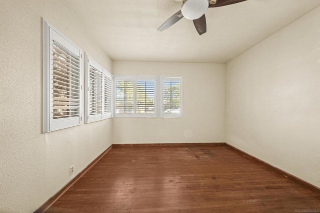 spare room featuring ceiling fan and dark wood-type flooring