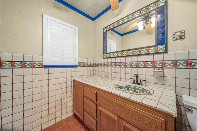 bathroom with vanity, tile patterned flooring, ceiling fan, toilet, and tile walls