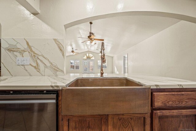 kitchen with backsplash, vaulted ceiling, ceiling fan, sink, and dishwasher