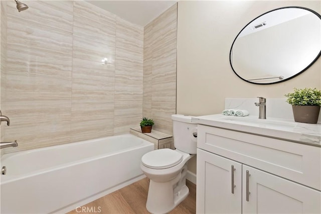 full bathroom with hardwood / wood-style floors, vanity, toilet, and tiled shower / bath